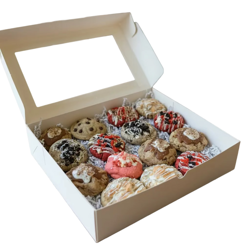 An assortment of decorated cookies arranged on a dark cooling rack, including chocolate chip cookies, pink frosted cookies, and drizzled chocolate and white icing cookies.